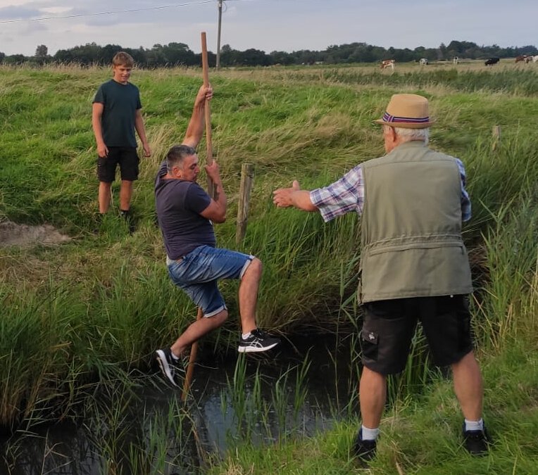 Junge sprikt am Klootstock über den Graben